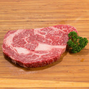 Rib eye steak with visible marbling, garnished with parsley
