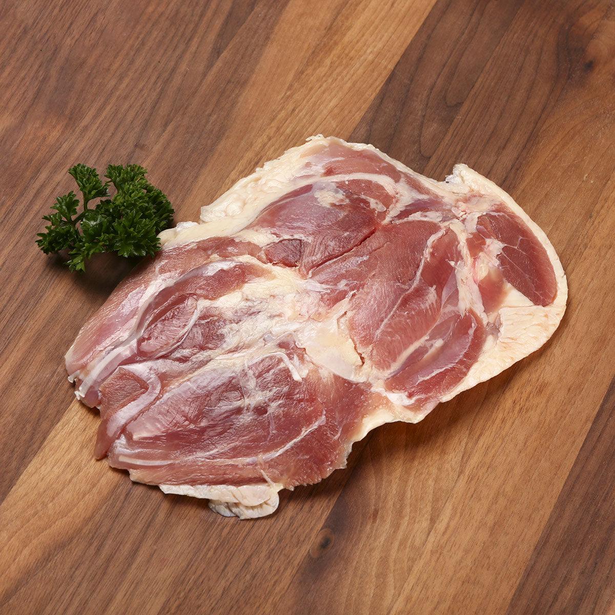 Frozen chicken thigh cut, marbled red and white meat with visible fat