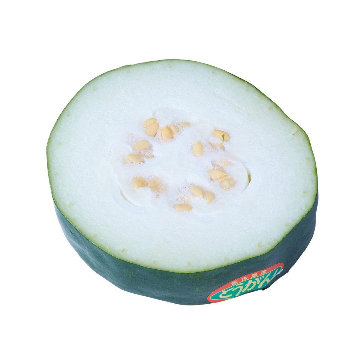 Japanese winter melon half with pale green flesh and seed-filled center