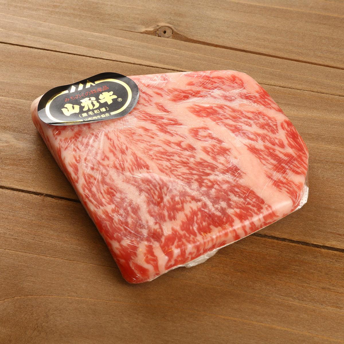Vacuum-sealed wagyu rib eye beef portion, bright red with white marbling
