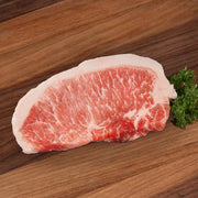 Raw boneless pork loin steak with marbled pink-red meat and white fat cap