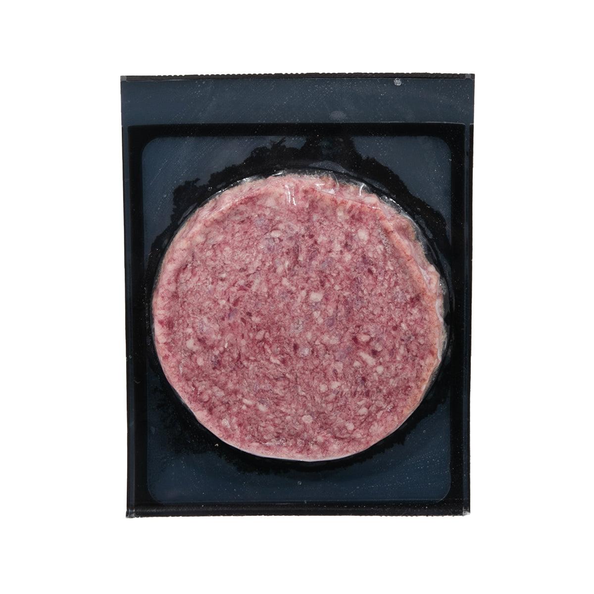 Frozen beef burger patty, round pink mince on black tray