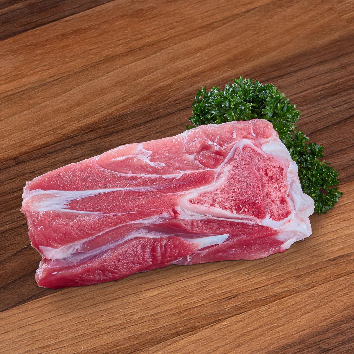 Chilled pork shin cut with visible fat marbling, with herb garnish