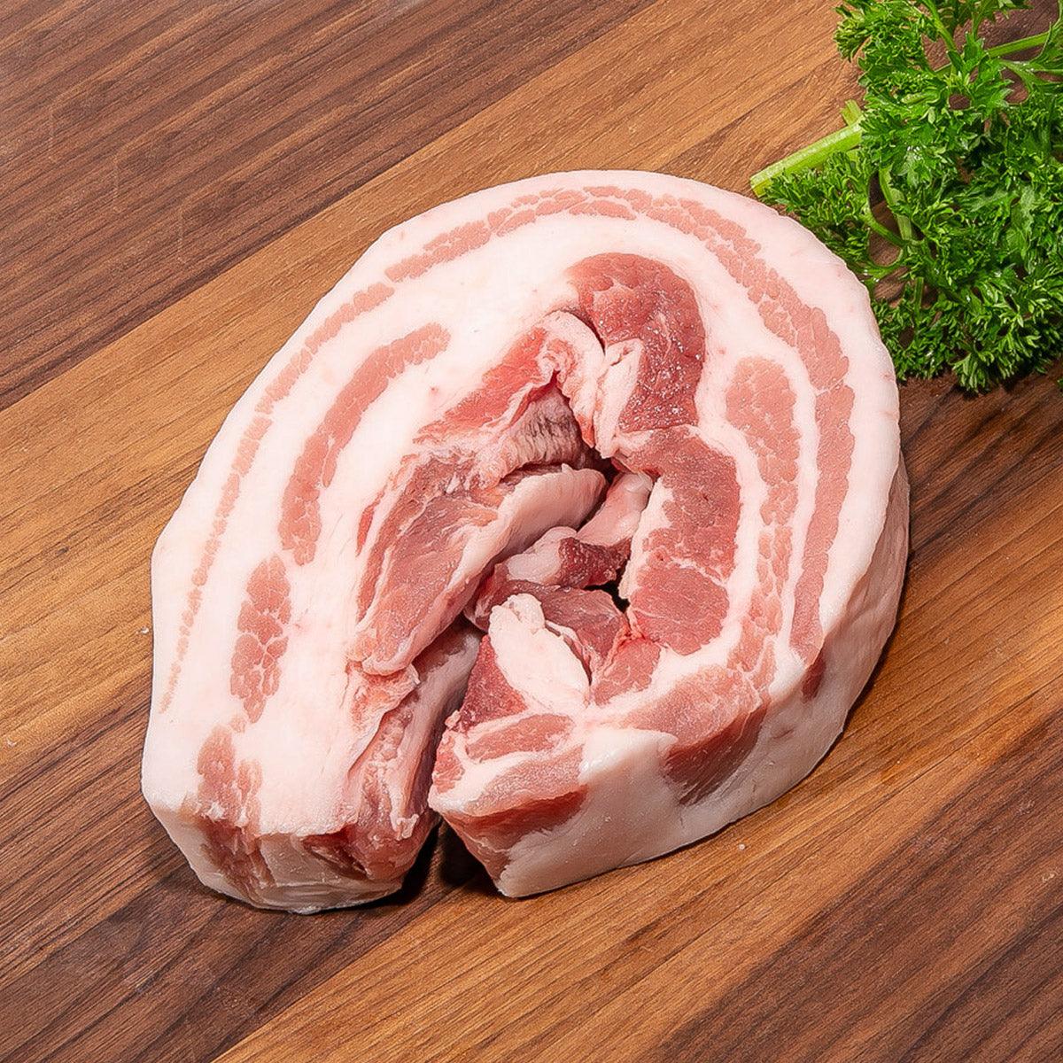 Frozen pork belly with thick white fat and pink meat, raw cut pieces