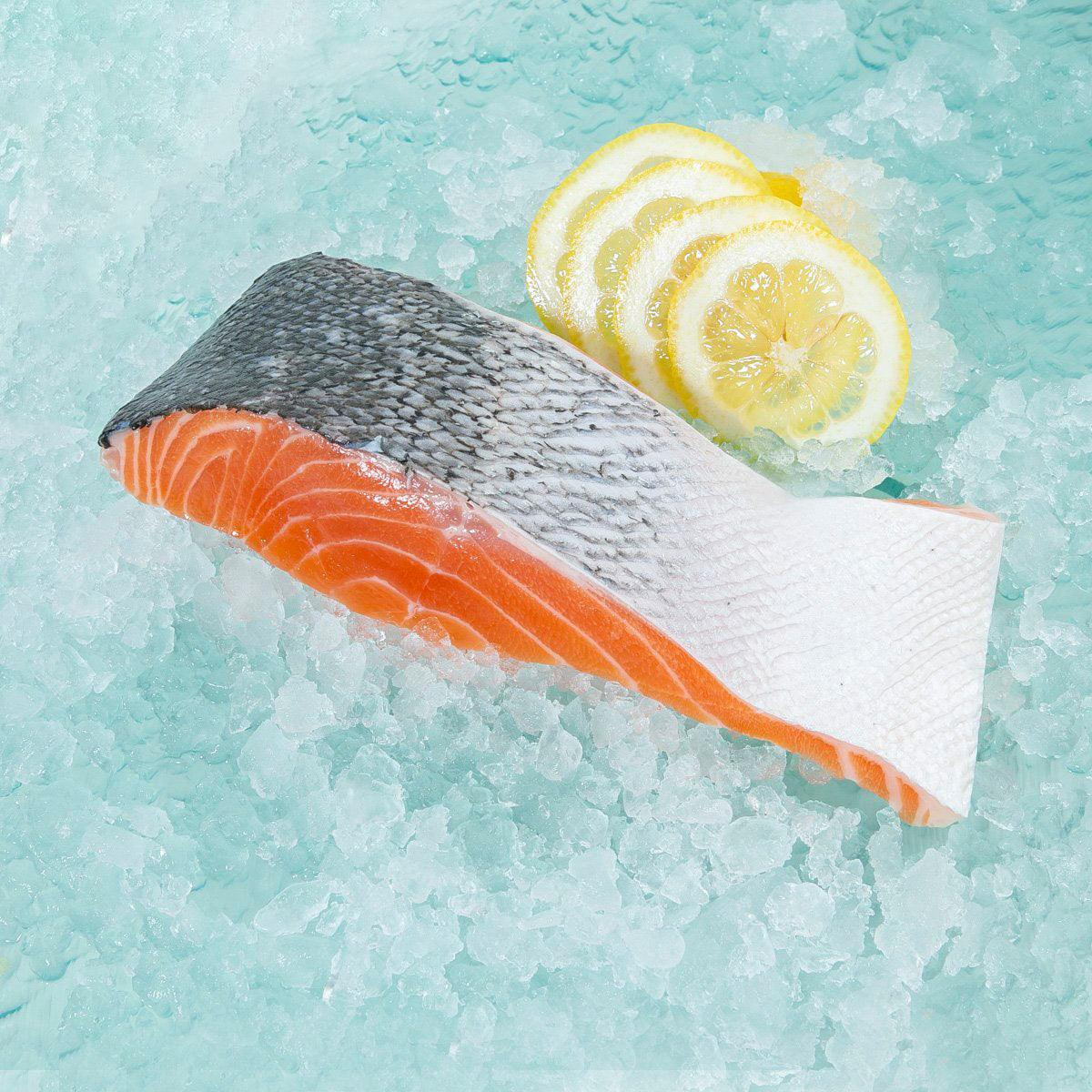 Chilled king salmon slice with orange flesh, wrapped with lemon slices