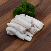 Italian veal tendon strips, pale white meat on a cutting surface