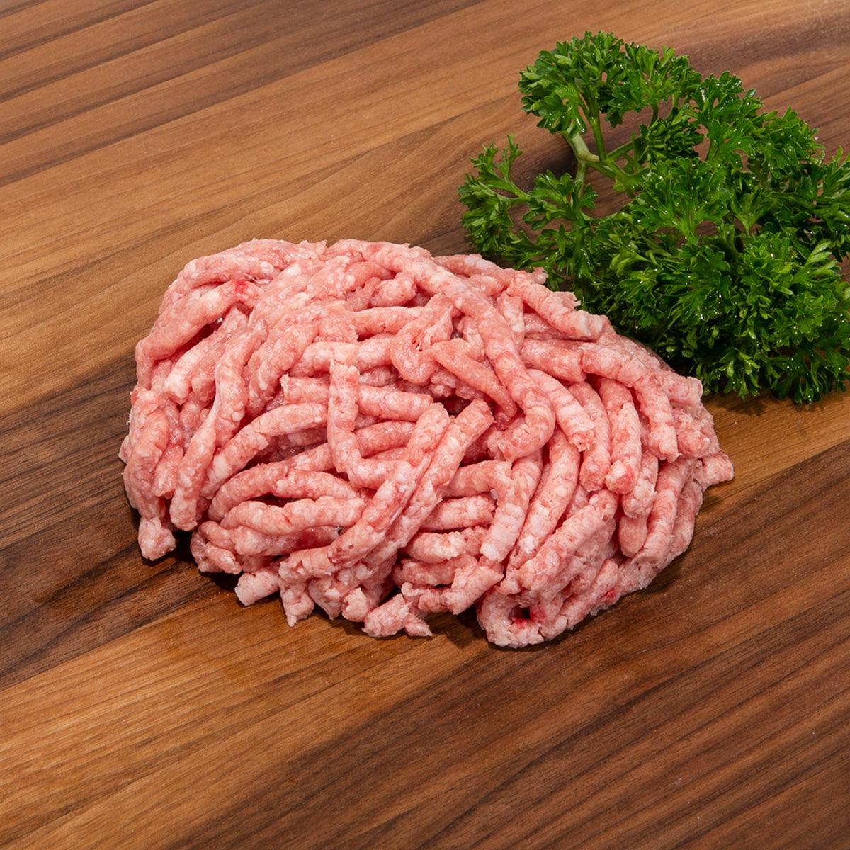 Raw minced pork mixture in a mound on a wooden surface