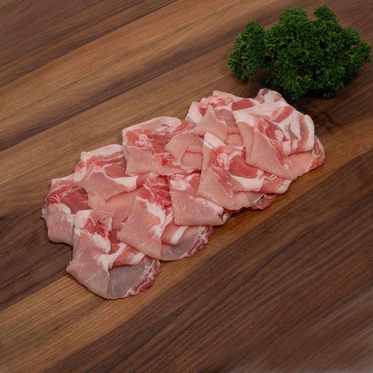 Raw pork belly pieces with visible fat, pink and white, ready for cooking