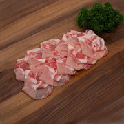 Raw pork belly pieces with visible fat, pink and white, ready for cooking