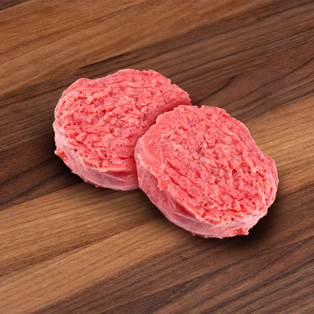Chilled raw beef tartare patties, two round portions of red minced meat.