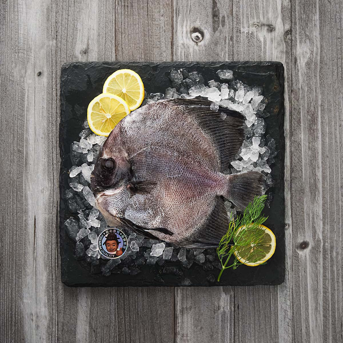 Whole frozen round batfish with crushed ice and lemon slices