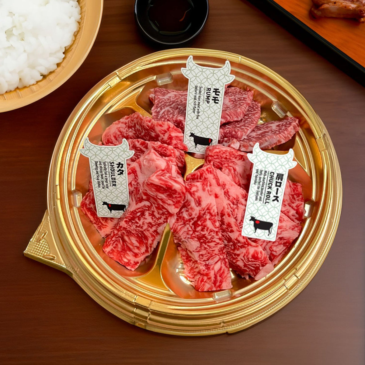 Chilled A5 wagyu yakiniku set in round gold tray with marbled beef slices