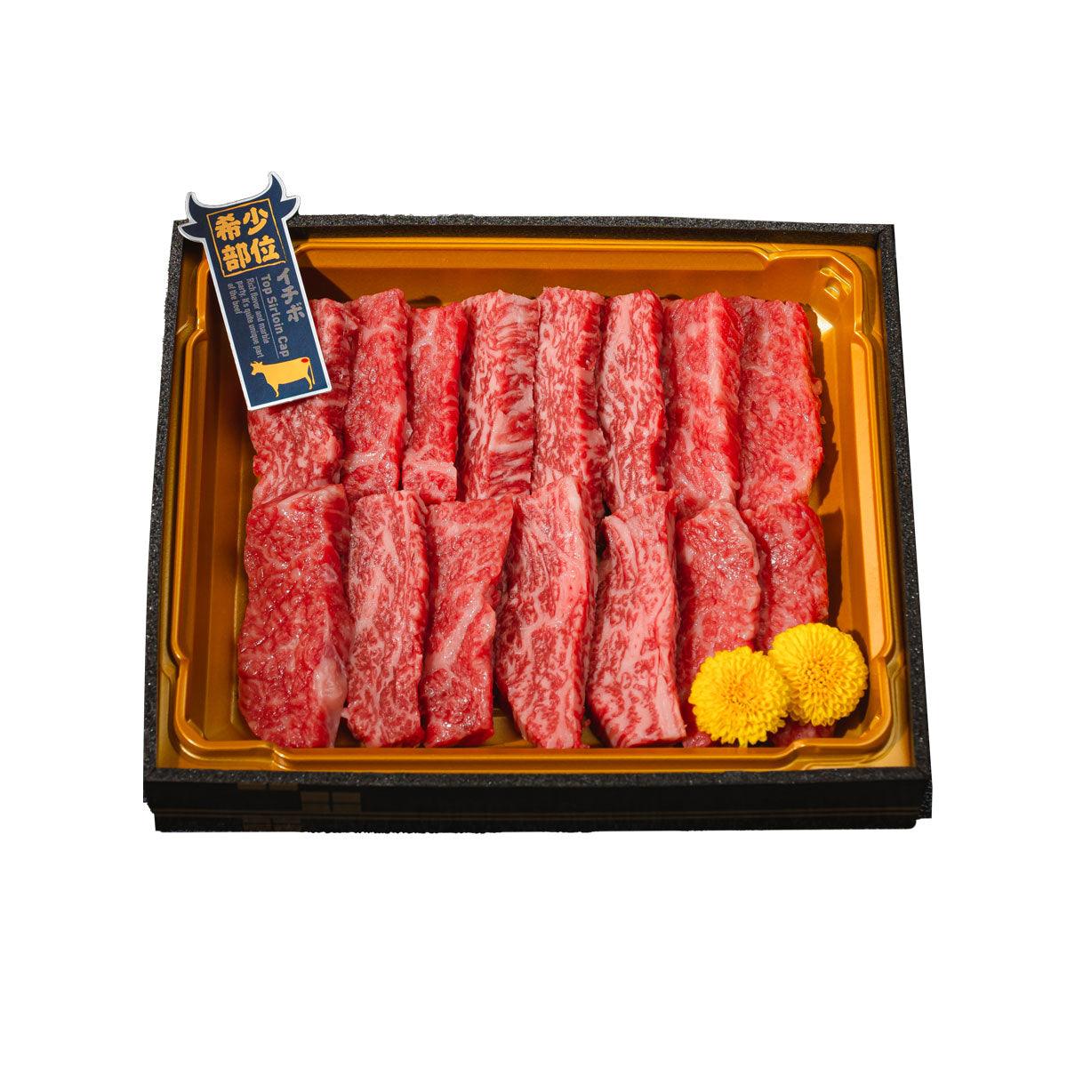 Packaged A5 wagyu beef strips in gold tray, red marbled slices with two yellow accents