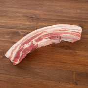Boneless organic pork belly strip with visible fat and pink meat