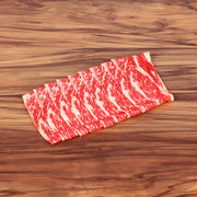 Raw beef short rib slices with red-and-white marbling, laid flat for shabu shabu