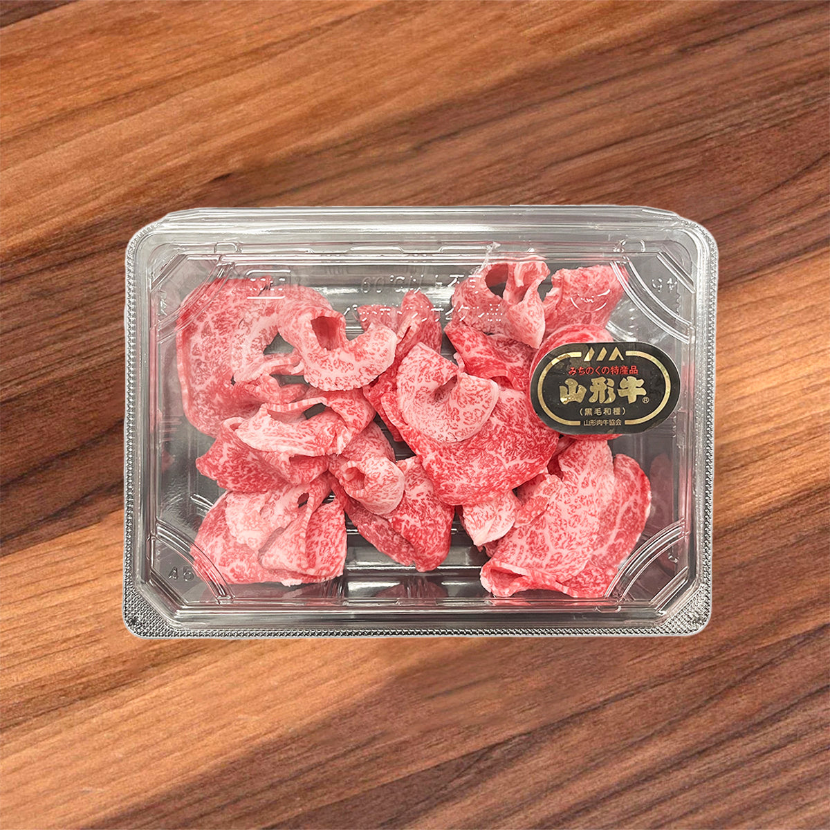 Marbled wagyu beef slices in clear tray, red kiriotoshi with visible fat veining