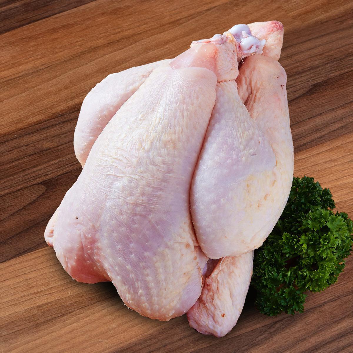 Chilled whole organic chicken pieces on a bed of fresh parsley
