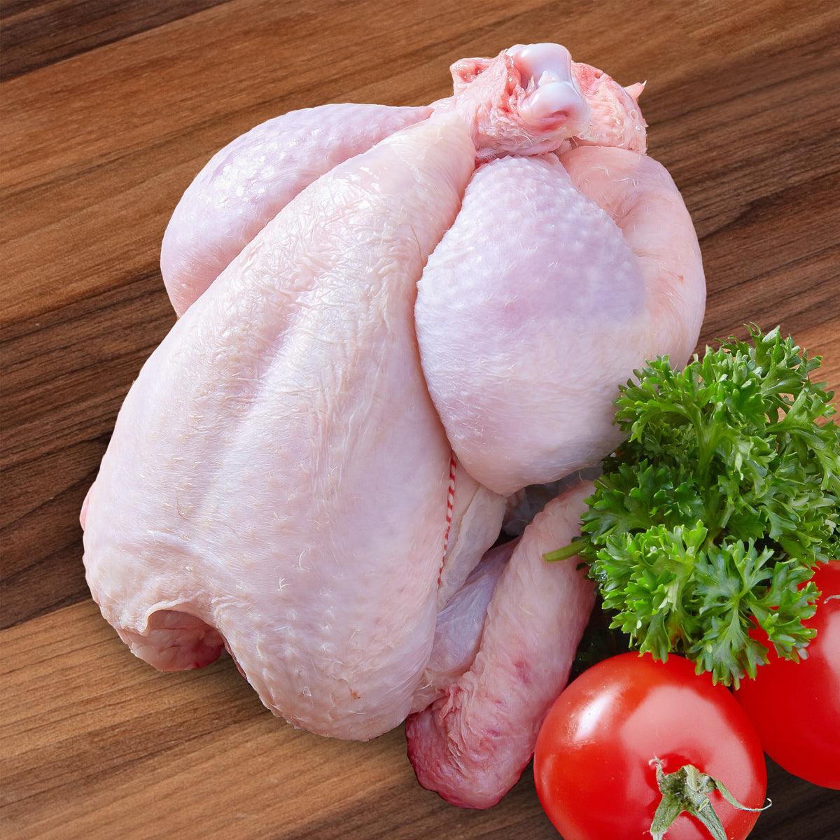 Raw spring chicken with pale pink skin, whole bird