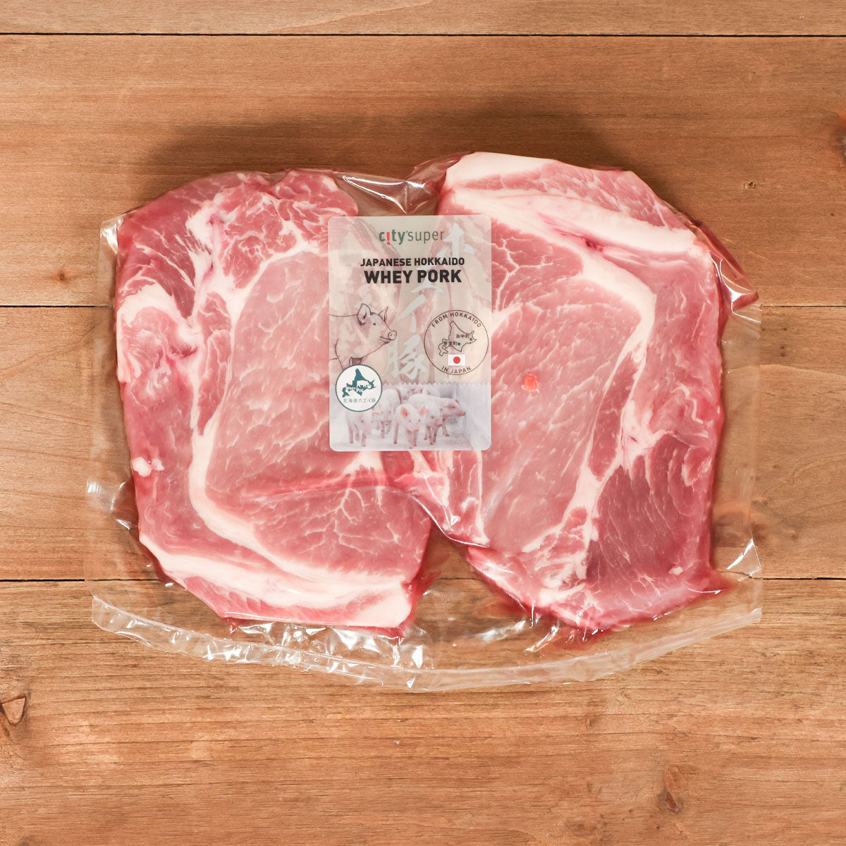 Frozen pork butt cuts in vacuum-sealed clear packaging, visible fat marbling and label