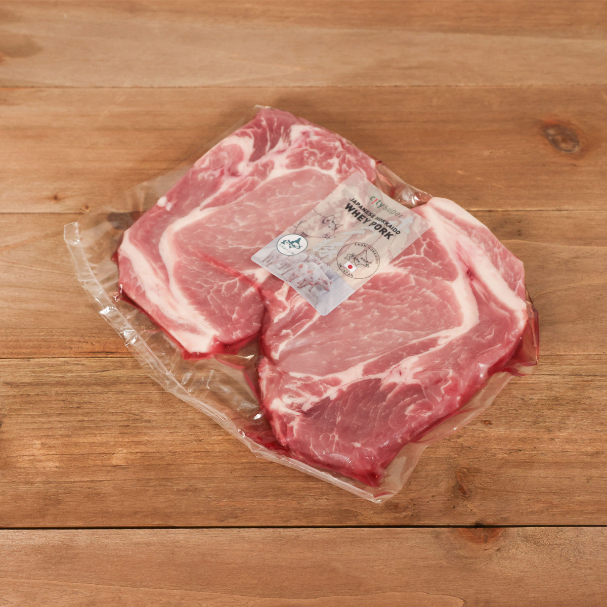 Frozen pork butt cuts with fat marbling in vacuum-sealed clear pack, label attached