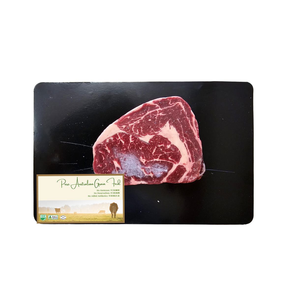 Frozen raw ribeye steak on black tray with product label