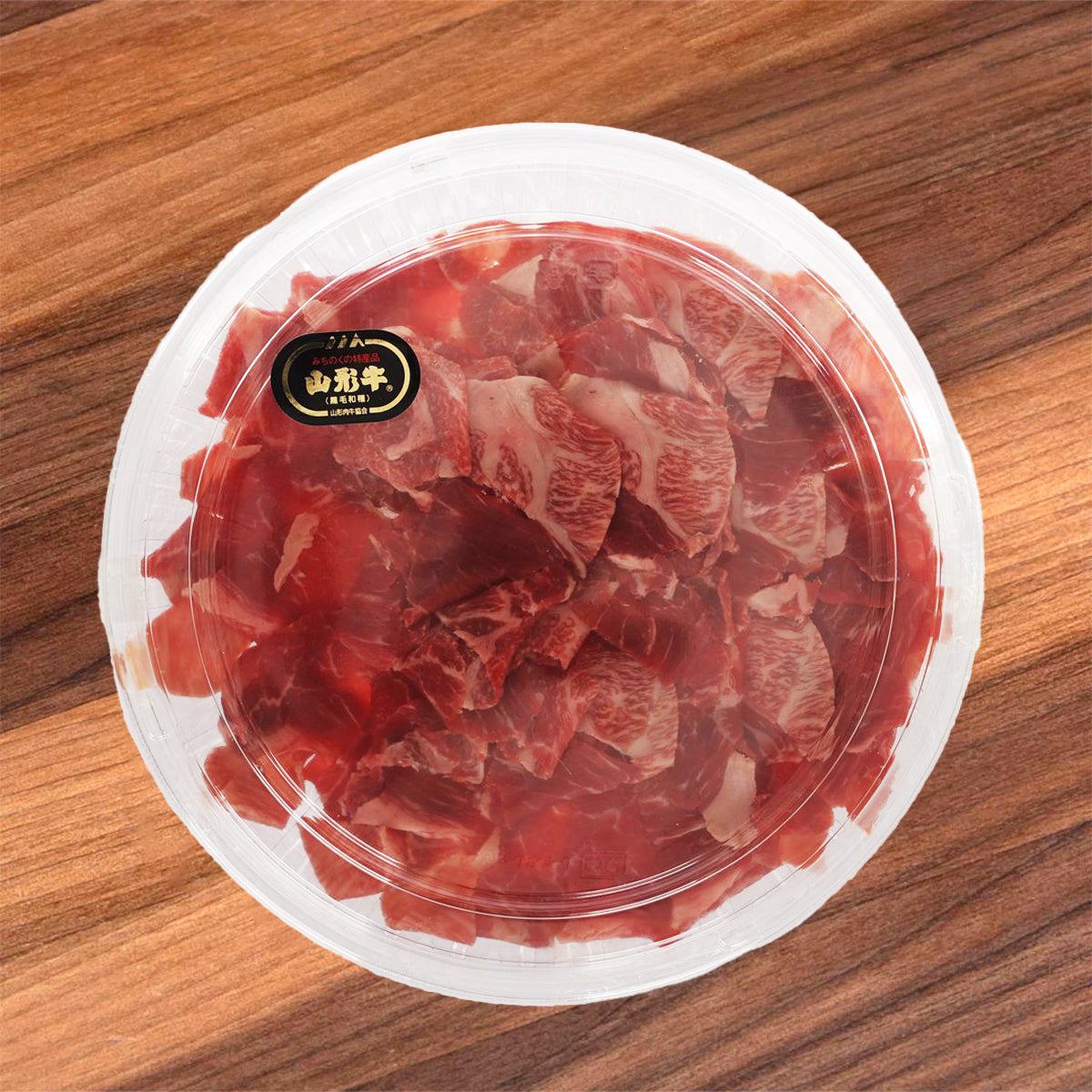Marbled wagyu beef kiriotoshi in clear plastic tray, red raw meat slices