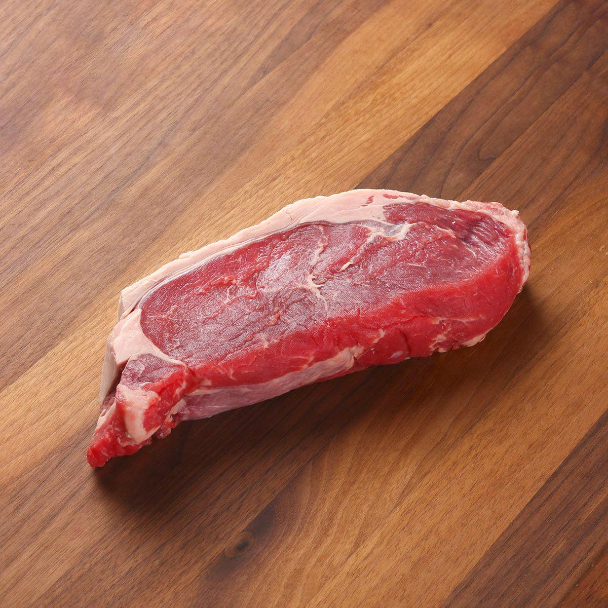 Chilled angus striploin steak, raw red meat with visible white marbling