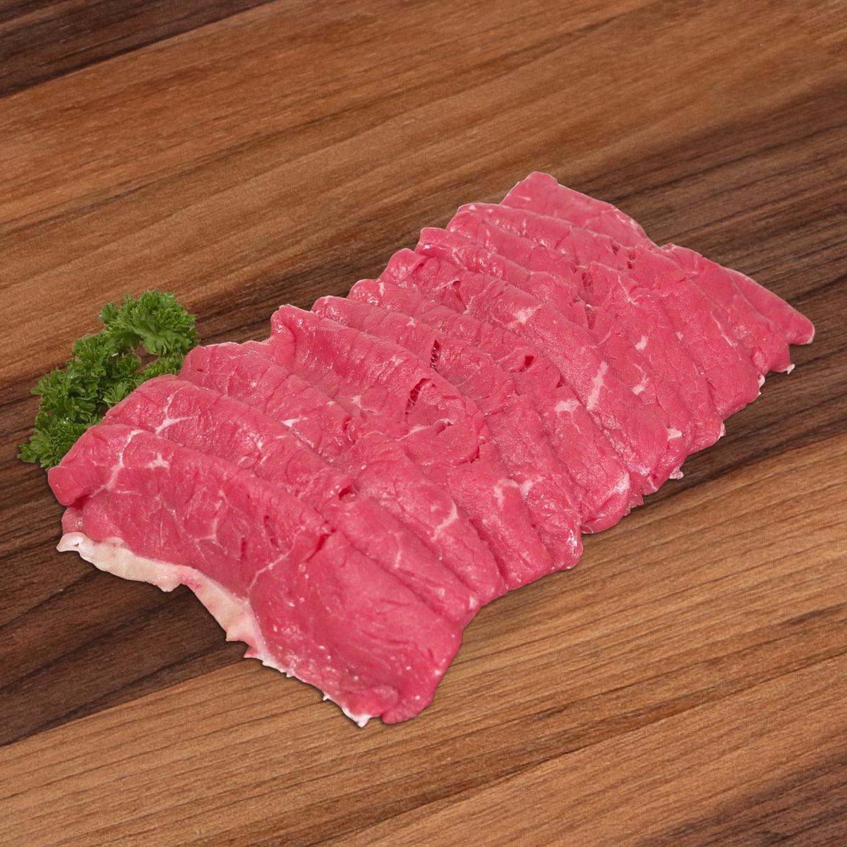 Chilled organic beef yakiniku slices, pink marbled raw meat pack piece