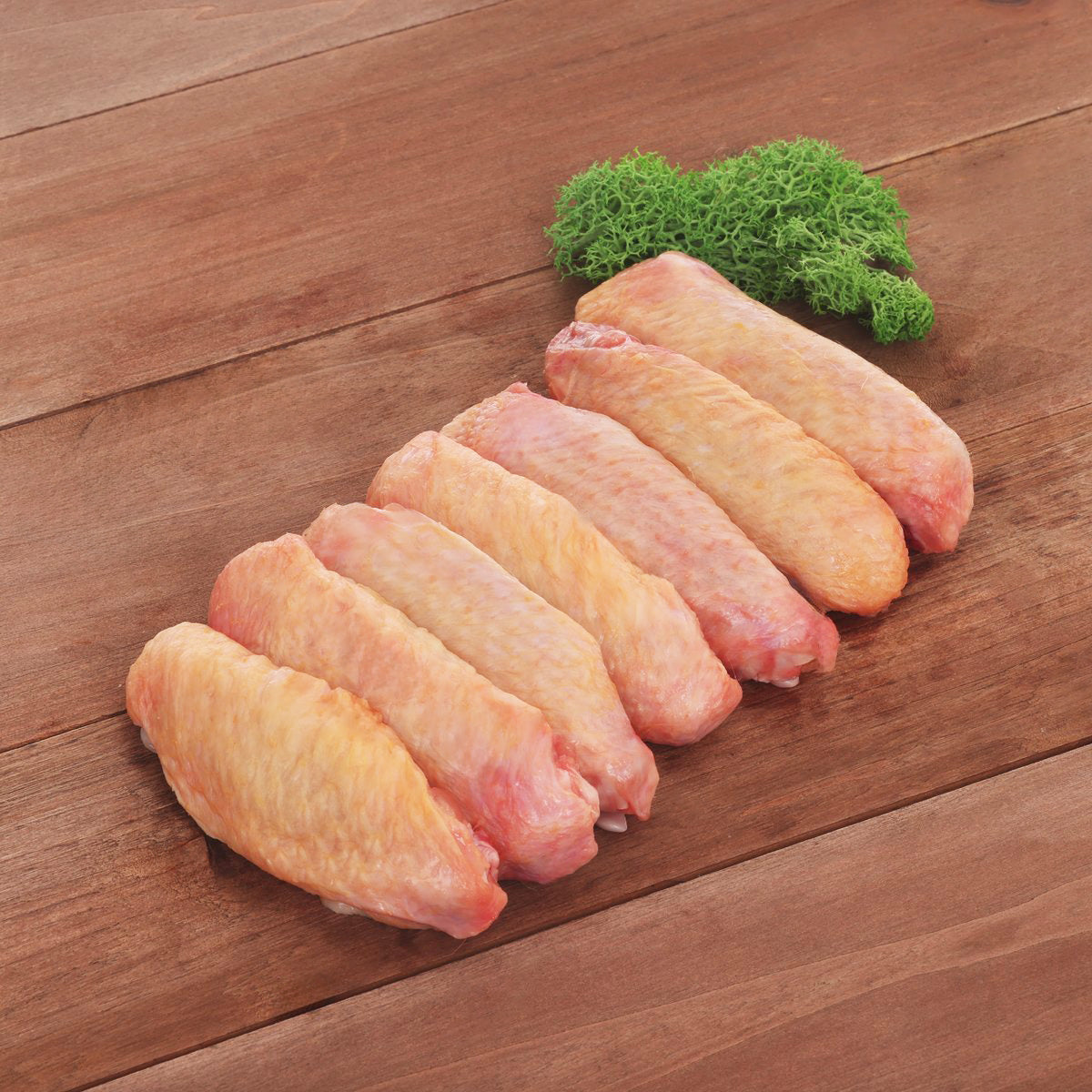 Frozen chicken wing mid joints, pale orange raw pieces