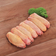 Frozen chicken wing mid joints, pale orange raw pieces