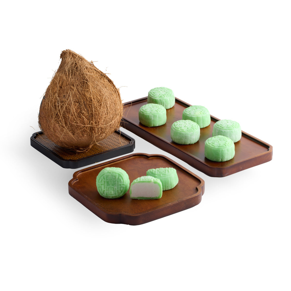 Assorted green snow-skin mooncakes on trays with coconut shell