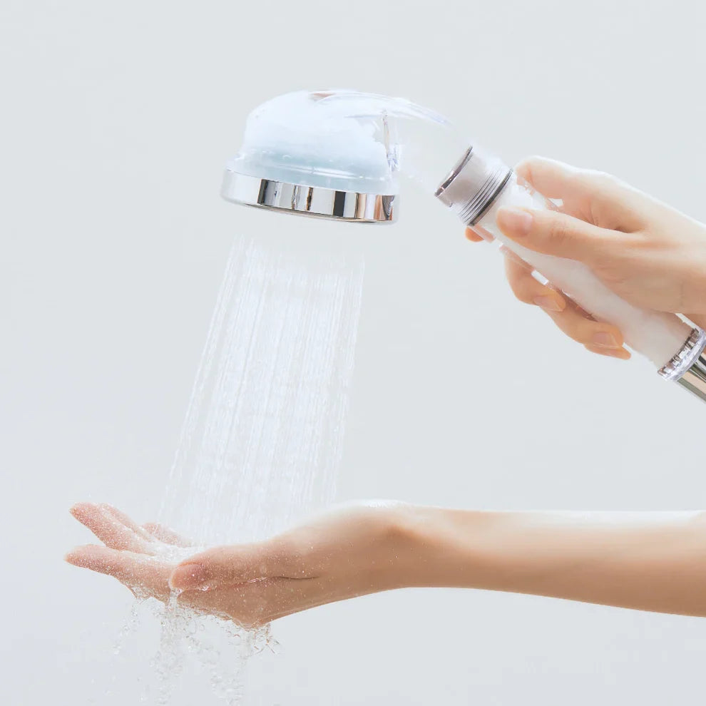 Handheld shower head spraying water into an open palm