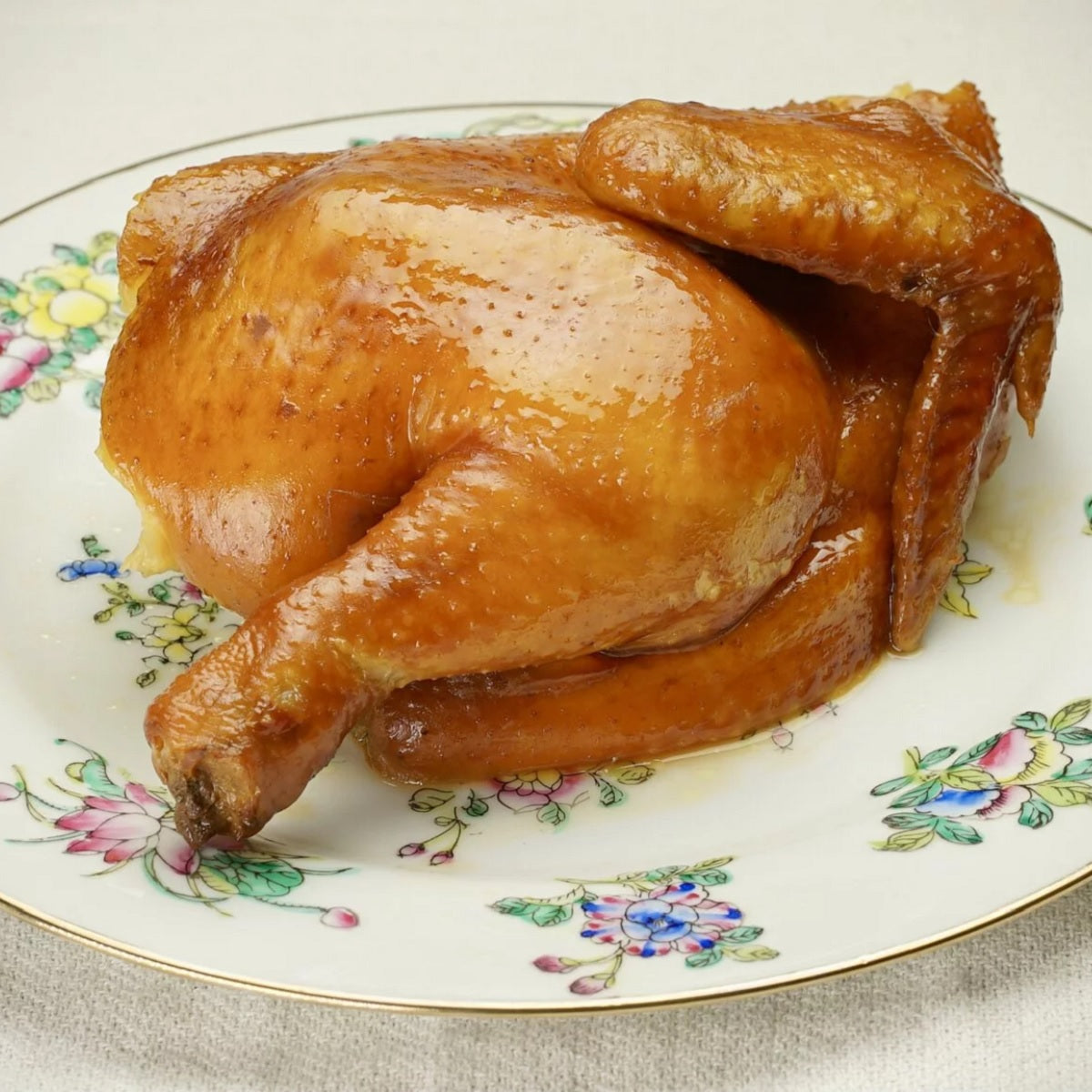 Tea-smoked chicken half with glossy sweet soy sauce on serving plate