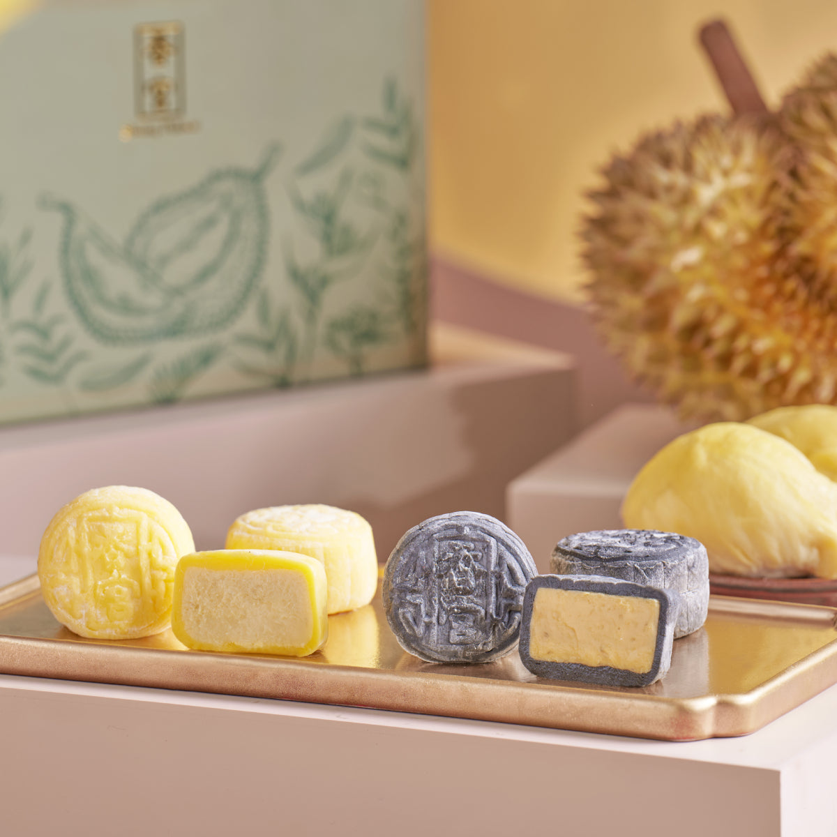 Mooncake duet set on tray with yellow, white, and dark snow skin pieces