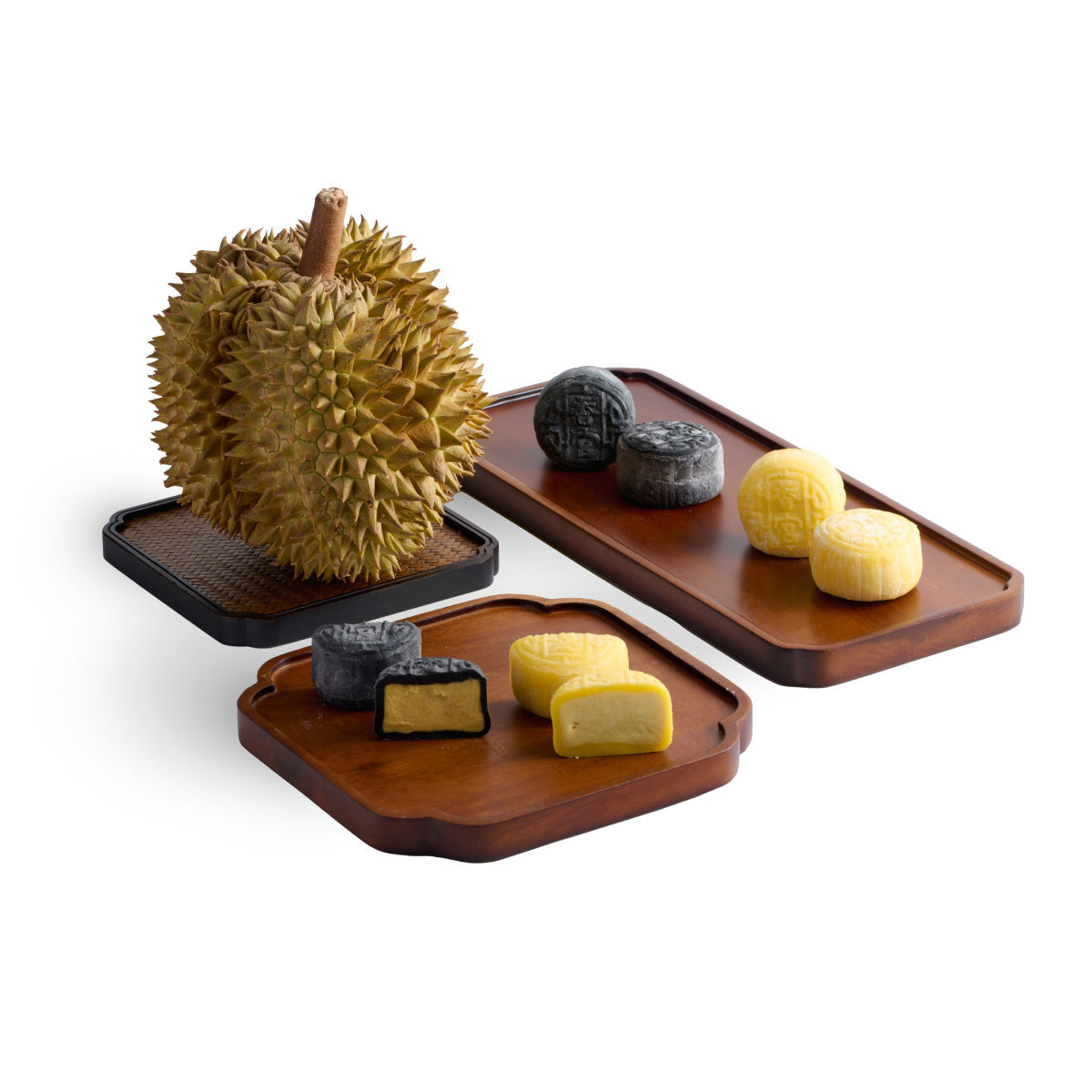 Snow skin mooncakes on two wooden trays with durian shell fruit