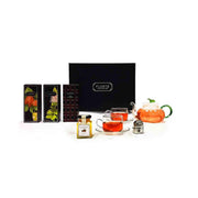 Tea gift set with orange teapot, cups and saucers, tea strainer, and seasoning jars