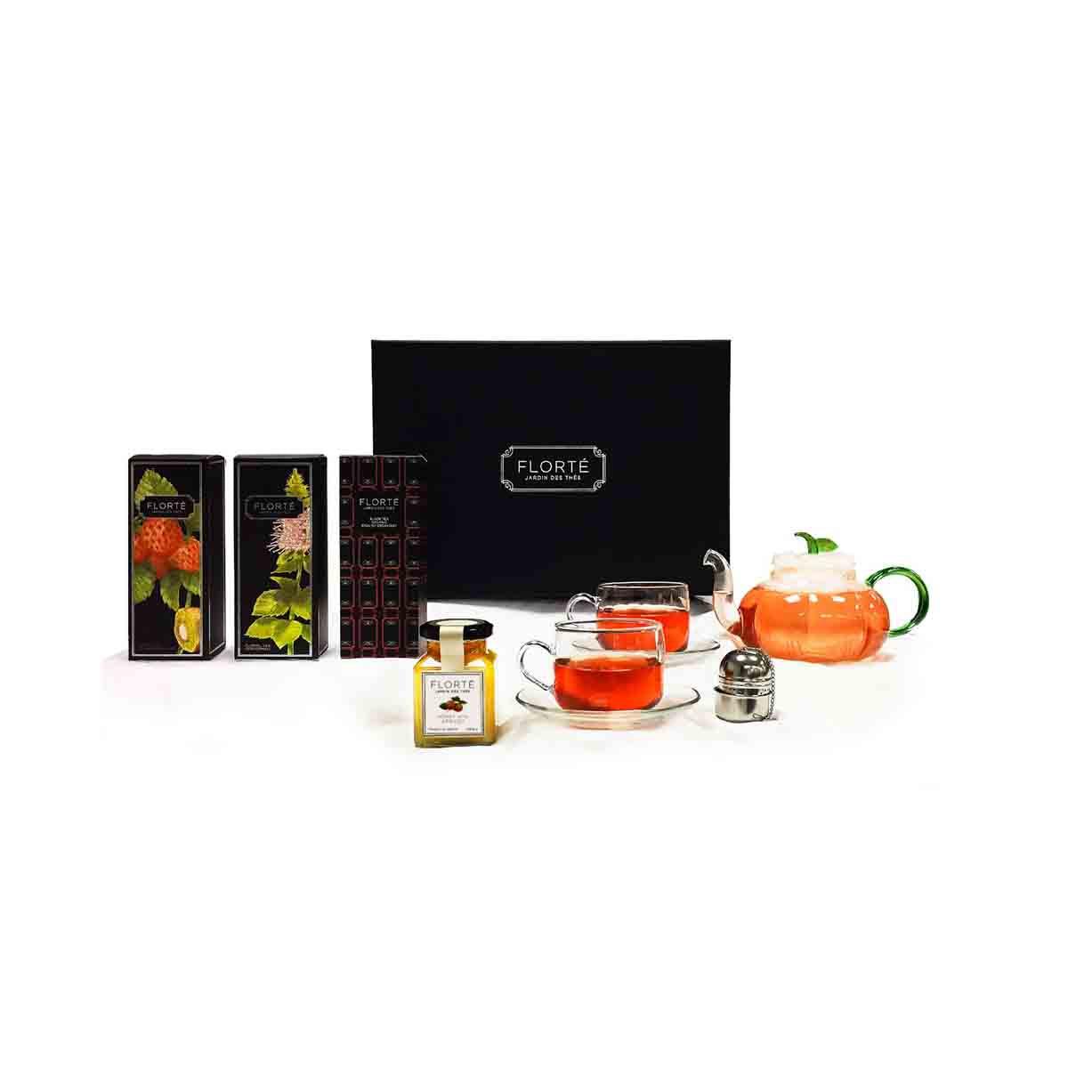 Tea gift set with orange teapot, cups and saucers, tea strainer, and seasoning jars