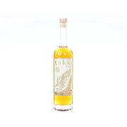Gold label soju bottle with clear glass and amber liquid, front label and cork top.