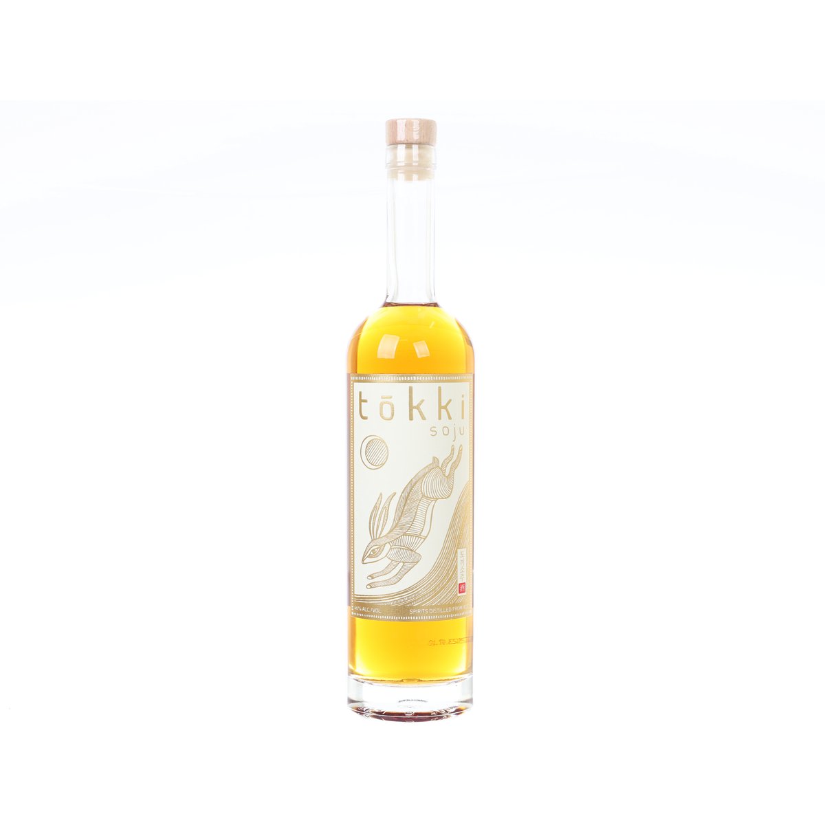 Gold label soju bottle with clear glass and amber liquid, front label and cork top.