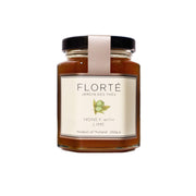 Glass jar of honey with lime, amber contents and branded front label