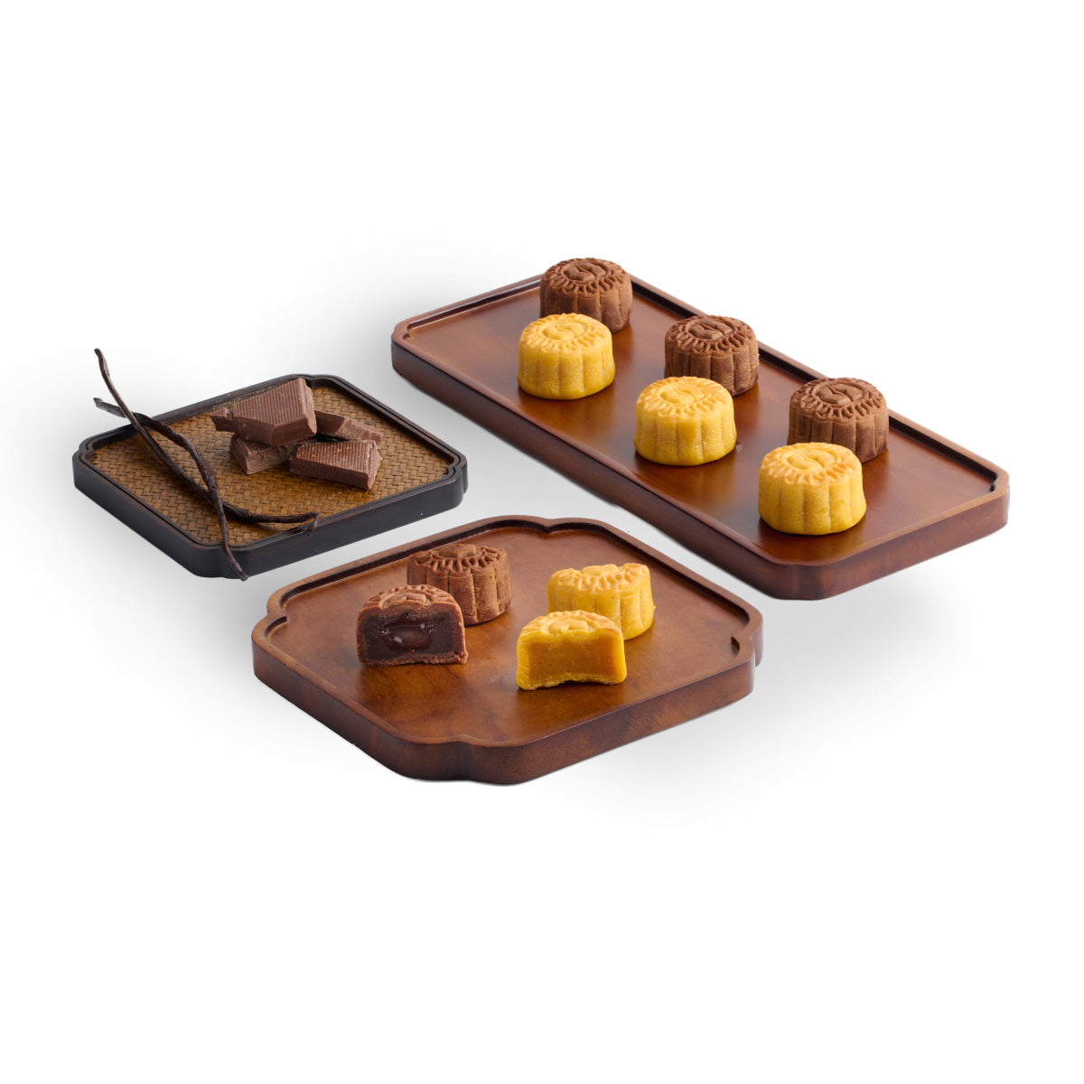 Three assortments of baked mooncakes on trays, with dark and yellow varieties