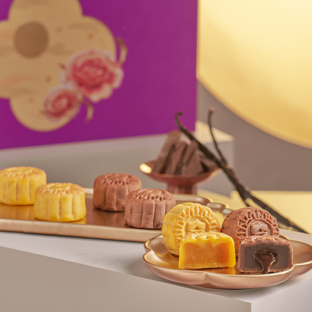Assorted mooncake duet pieces on a small plate: golden and brown pastries