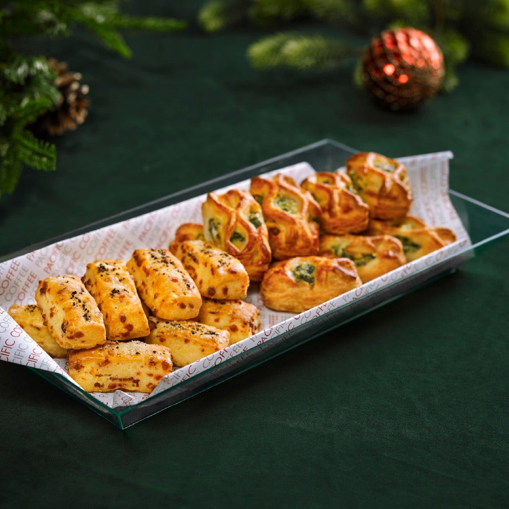 Rectangular pastry platter with assorted savory bites, baked pastries in a glass tray