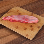 Raw beef shin cut on bamboo chopping board, red with light fat marbling