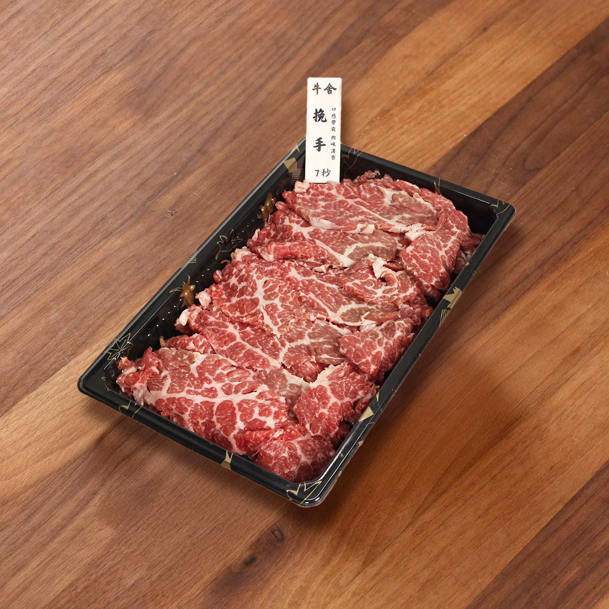 Sliced beef hot pot plate on black tray, red marbling meat strips
