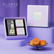 Mooncake gift set in open gift box with assorted pastries and labeled tea box