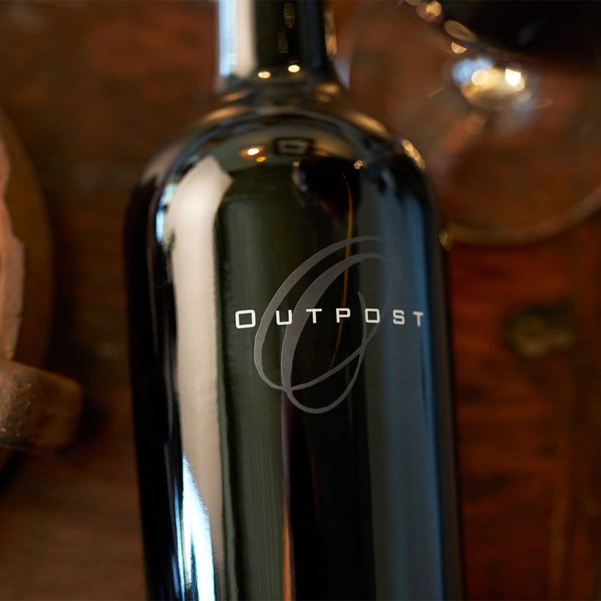 OUTPOST wine bottle neck and foil label close-up, dark glass