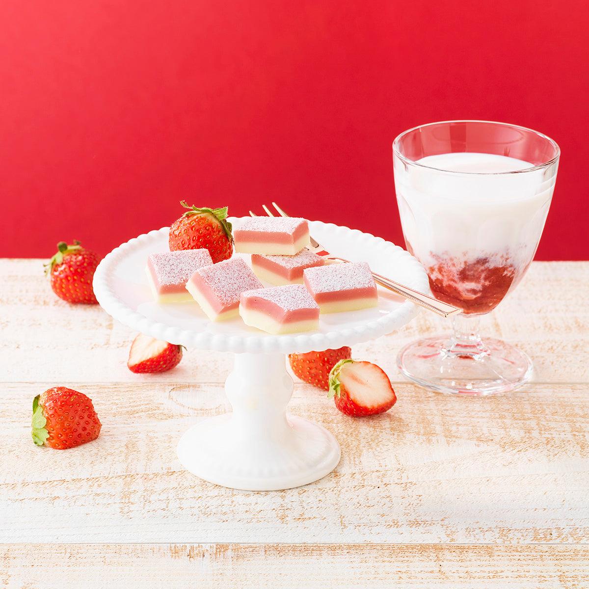 Strawberry milk nama chocolate squares with strawberries on white plate and glass