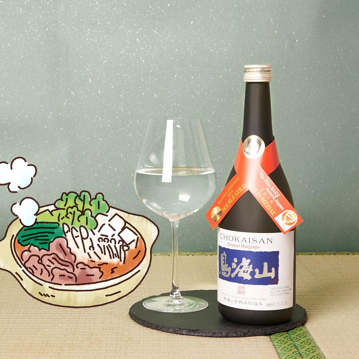 Sake bottle with front label beside a wine glass