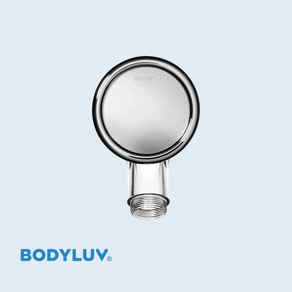 Round face of chrome shower head with central spray holes and hose outlet